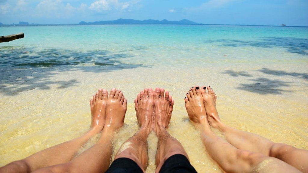 Kolme henkeä makaa rannalla