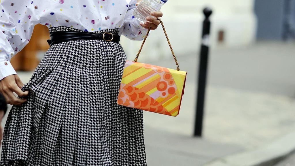 Minimittaiset helmat ja leveät lahkeet pukevat lyhyttä kaunotarta. Kuvituskuva.