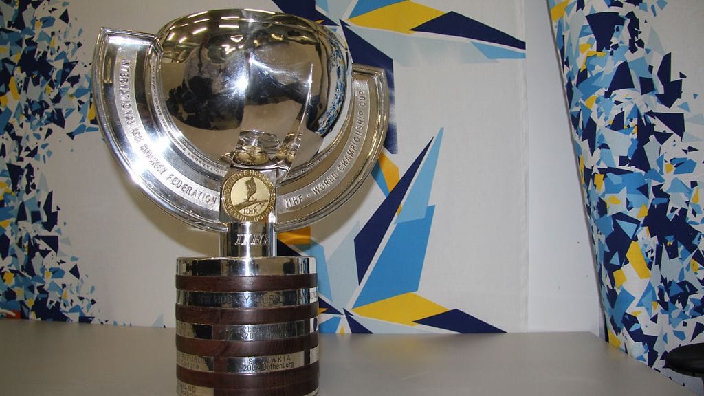 IIHF:ssä johtajana työskentelevä Hannes Ereder kiillotti palkintopokaalia pronssiottelun alla.