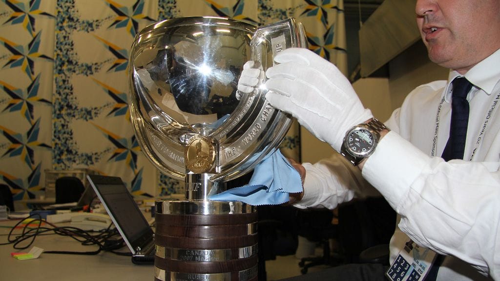 IIHF:ssä johtajana työskentelevä Hannes Ereder kiillotti palkintopokaalia pronssiottelun alla.