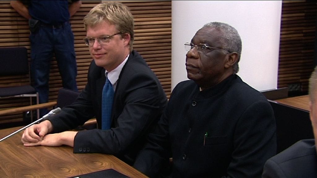 Oikeustieteen maisteri Ville Hoikkala ja joukkotuhonnasta syytetty Francois Bazaramba Helsingin hovioikeudessa 22.8. 2011