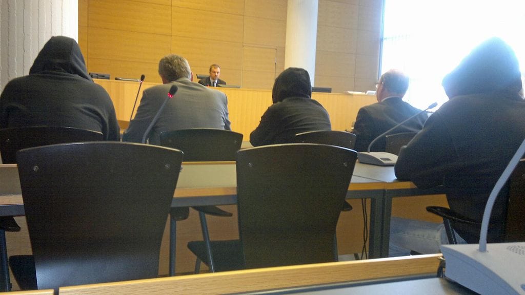 Syytetyt kuuntelivat huput päässä, kun käräjätuomari julisti tuomion pride-kulkueen kaasuiskusta 3.5.2011 Helsingin käräjäoikeudessa.. (kuva: MTV3)