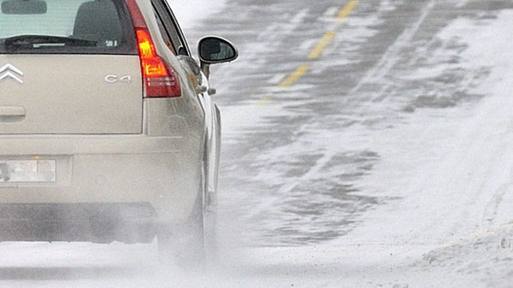 Kuvituskuvassa auto lumisella maantiellä.