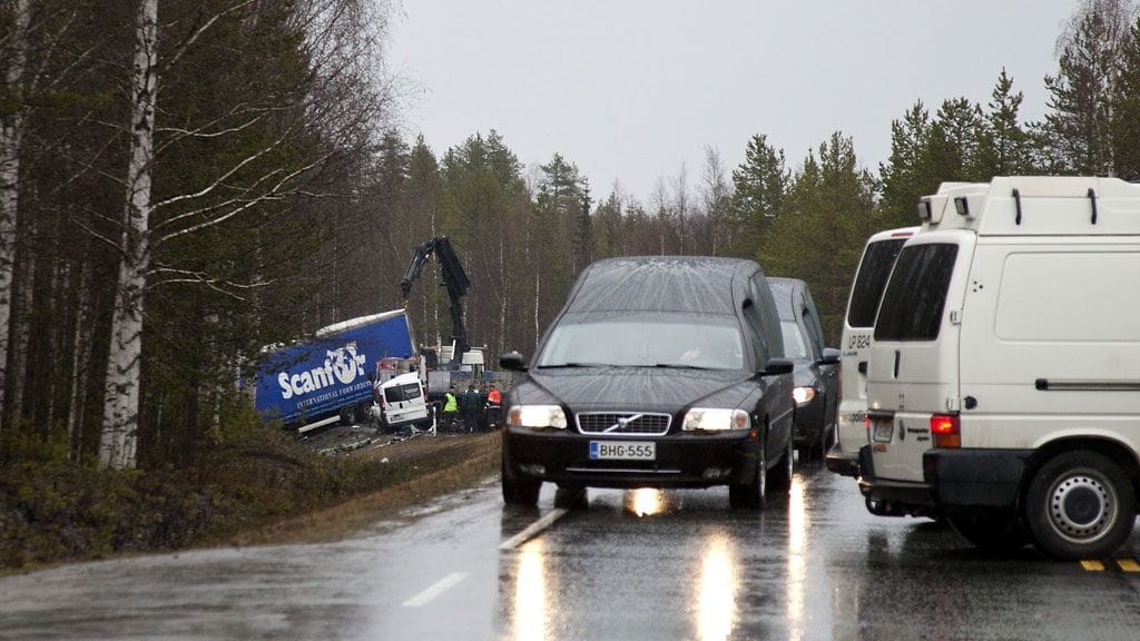 Ruumisautot poistuvat kolaripaikalta, jossa neljä ihmistä sai surmansa.