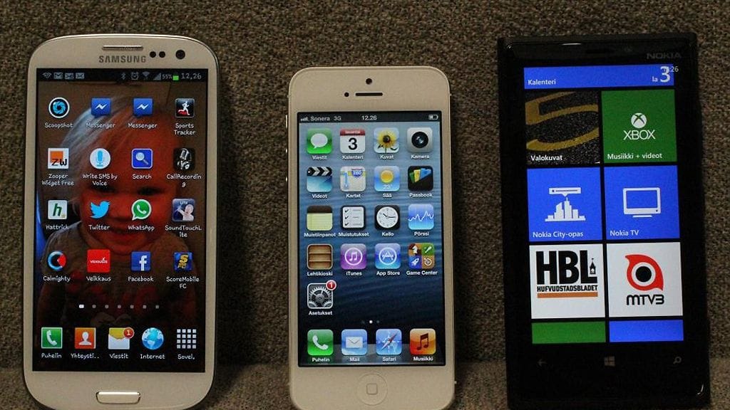 Testipuhelimet vierekkäin: Samsungin Galaxy S III, iPhone 5 ja Nokian Lumia 920.