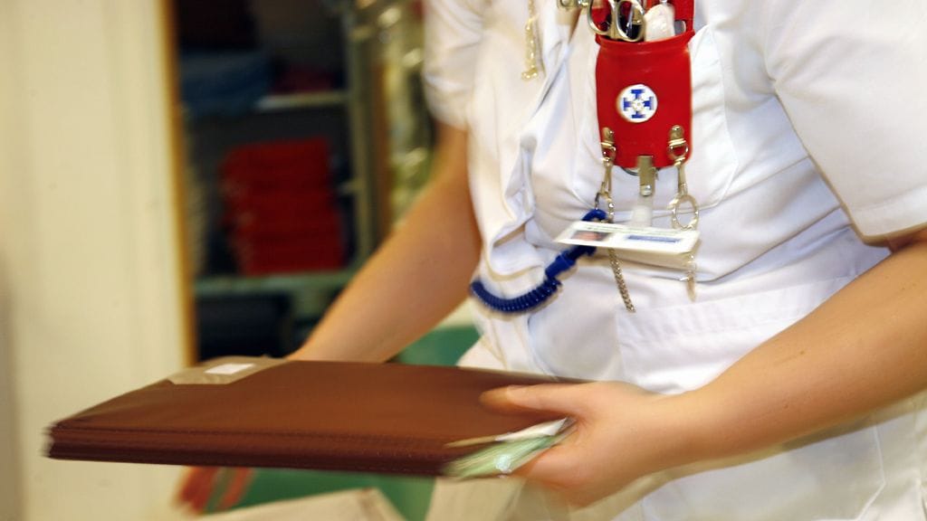 Sairaanhoitaja tekee paperitöitä osaston toimistossa Jorvin sairaalassa.