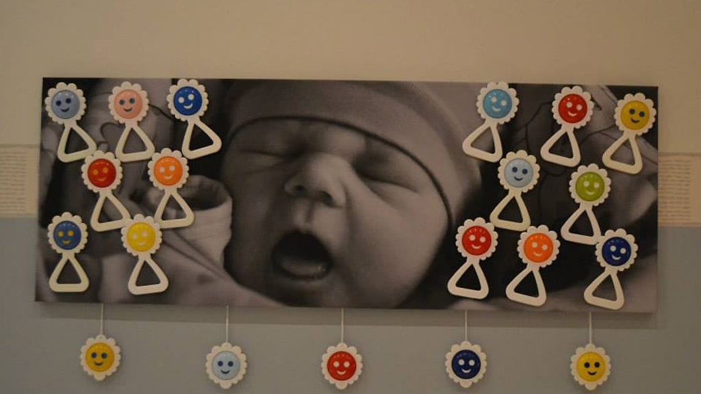 Emilia, ikää muutama tunti, poseeraa äidin helistinkokoelman kanssa