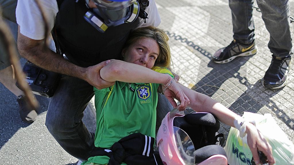 Naispuolinen Brasilia-fani kärsi poliisin käyttämän kyynelkaasun vaikutuksista ennen kisojen avauspeliä.