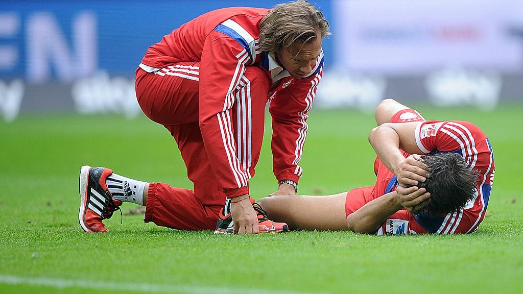 Javi Martinez tuskailee polvivammaansa kentän pinnassa.