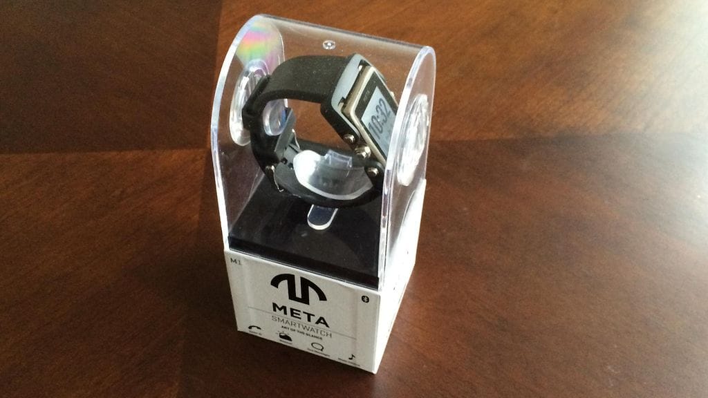 META M1 -älykello esiintyy edukseen läpinäkyvässä tuotepakkauksessa.