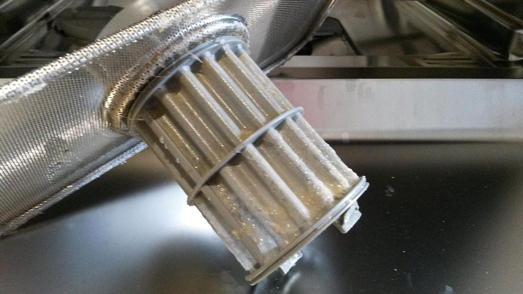 Hyvin likainen suodatin, jossa on rasvaa ja pullataikinaa.