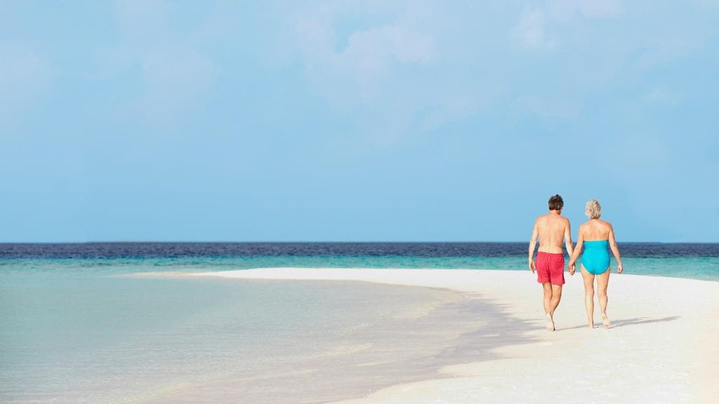 Pari kävelee meren rannalla