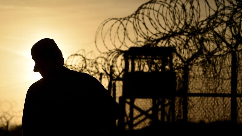 Huhtikuussa 2014 otetussa kuvassa amerikkalaissotilas kävelee jo käytöstä poistetun vankialueen vieressä.