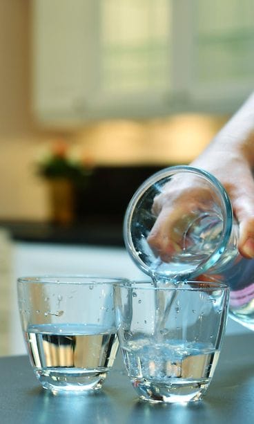Vettä kaadetaan lasiin