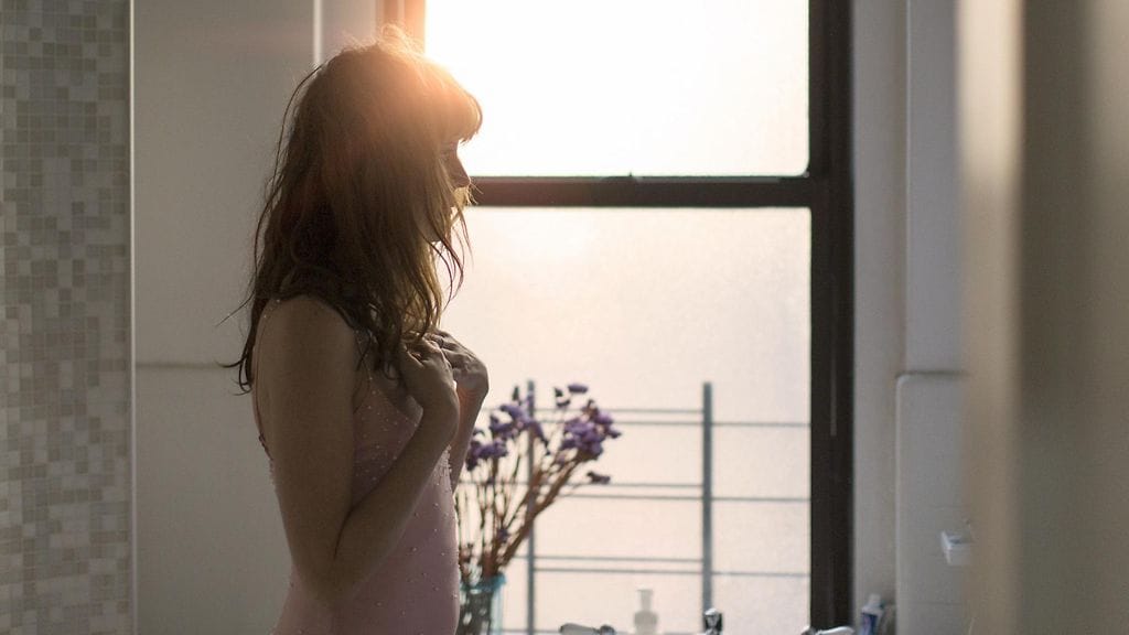 Nainen seisoo ikkunan ääressä
