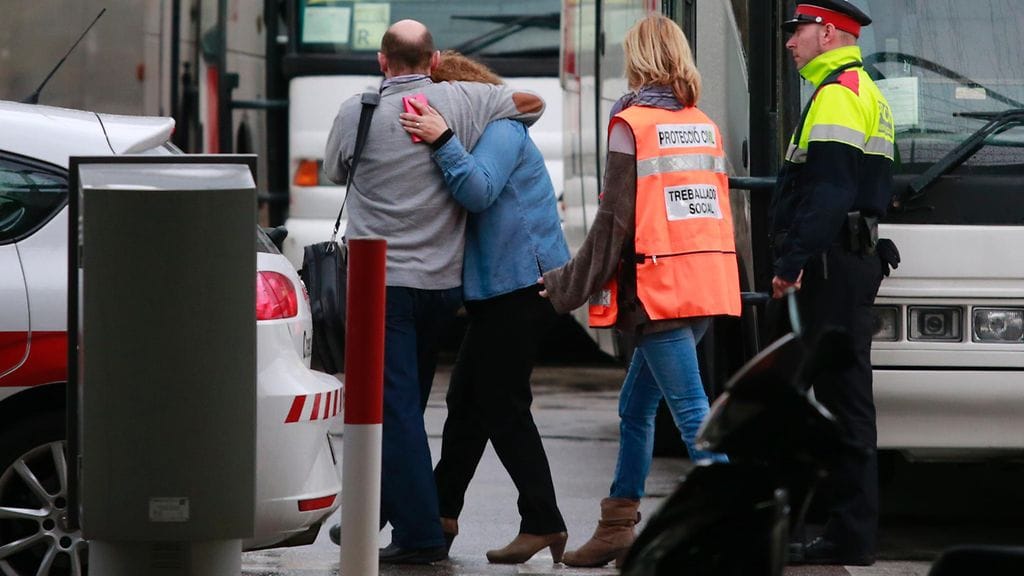 Lento-onnettomuudessa menehtyneiden uhrien omaisia Barcelonan lentokentällä.