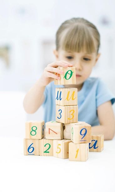 Tyttö leikkii palikoilla