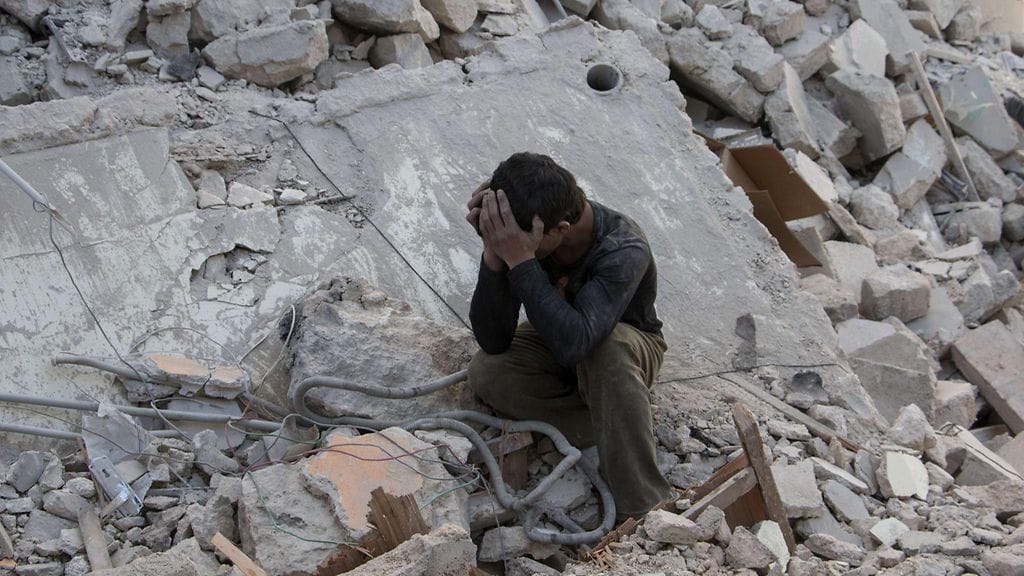 Syyrialaispoika suri talon raunioilla Syyrian hallituksen joukkojen tekemän ilmaiskun jälkeen Aleppossa 13. huhtikuuta 2015.