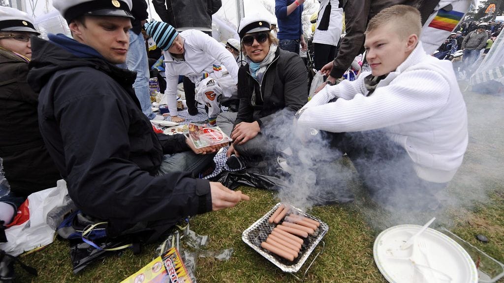 Juhlijat grillaavat nakkeja kertakäyttögrillillä Kaivopuistossa Helsingissä vapunpäivänä 1. toukokuuta 2010.