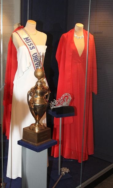 Anne Pohtamon Miss Universum -loppukilpailupuku sekä punainen semifinaalipuku Tamminiemen Miss Universum 1975 -näyttelyssä.