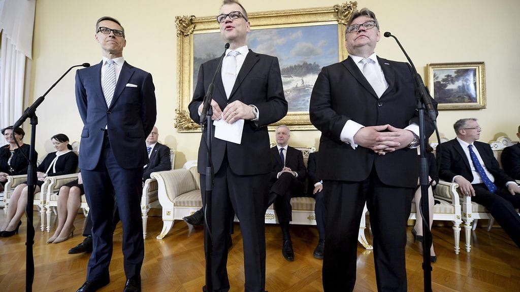 Puheenjohtajakolmikko uuden hallituksen ensimmäisessä tiedotustilaisuudessa.