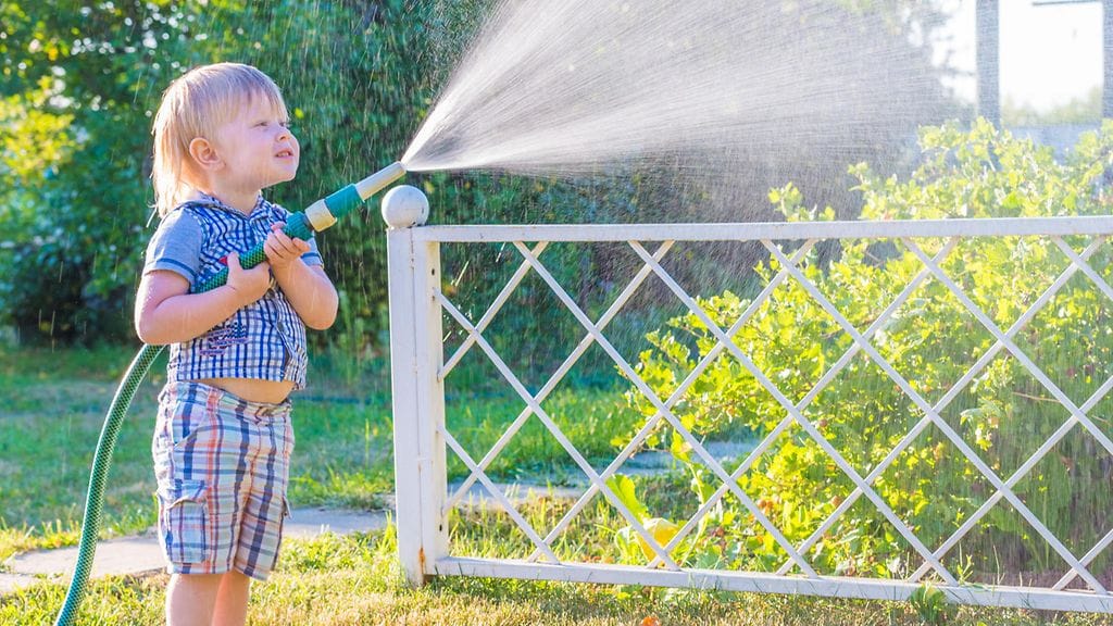 Lapsi kastelee pihaa