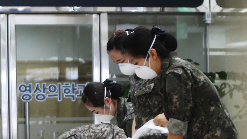 Kaikki uudet tartuntatapaukset ovat saaneet alkunsa sairaaloissa. Kuvassa armeijan lääkärit ovat suojatumassa ennen menoaan sairaalaan Soulissa.