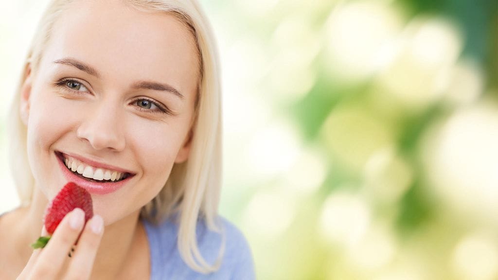 Nainen syö mansikan