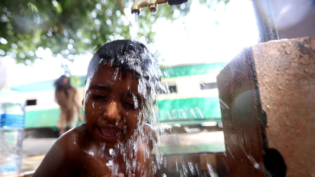 Pikkupoika hakee viilennystä paahtavaan kuumuuteen Karachissa Pakistanissa 23.6.2015.