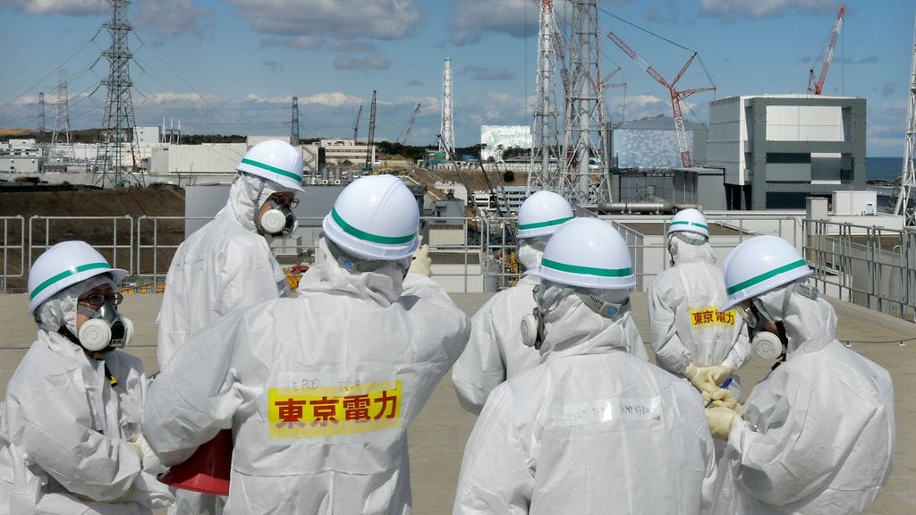 Fukushiman ydinvoimalan lähellä pitää suojautua säteilyltä tarkoin vielä neljä vuotta onnettomuuden jälkeenkin. Kuvassa on joukko toimittajia ja voimalatyöntekijöitä tarkistamassa voimala-aluetta.