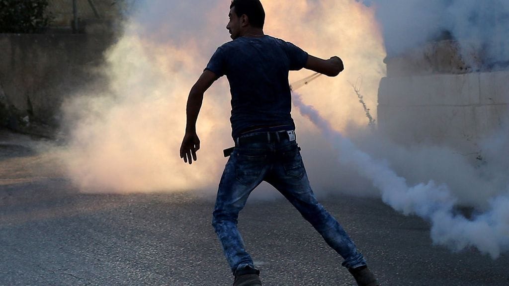 Kuvassa palestiinalainen mies uhmaa israelilaisia sotilaita.