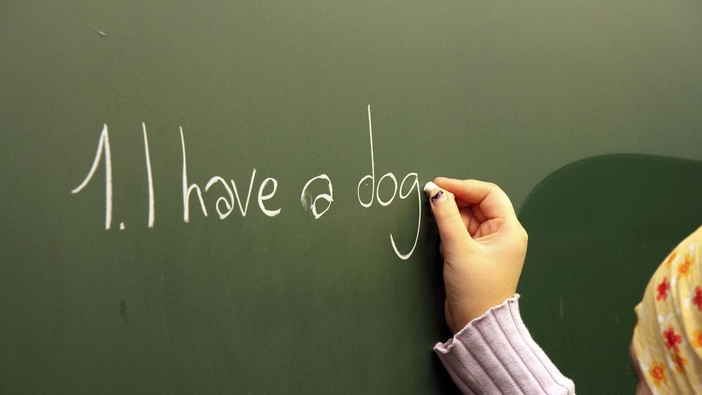 Lapsi kirjoittaa taululle koulussa