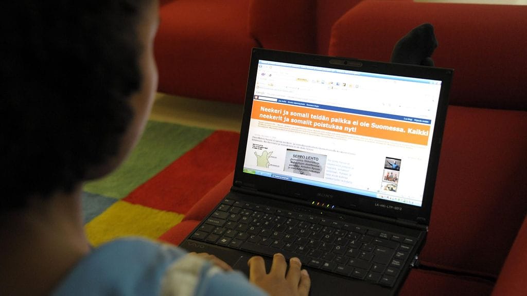 Kaksikulttuurinen nuori selailee maahanmuuttajavastaista internet-sivustoa.