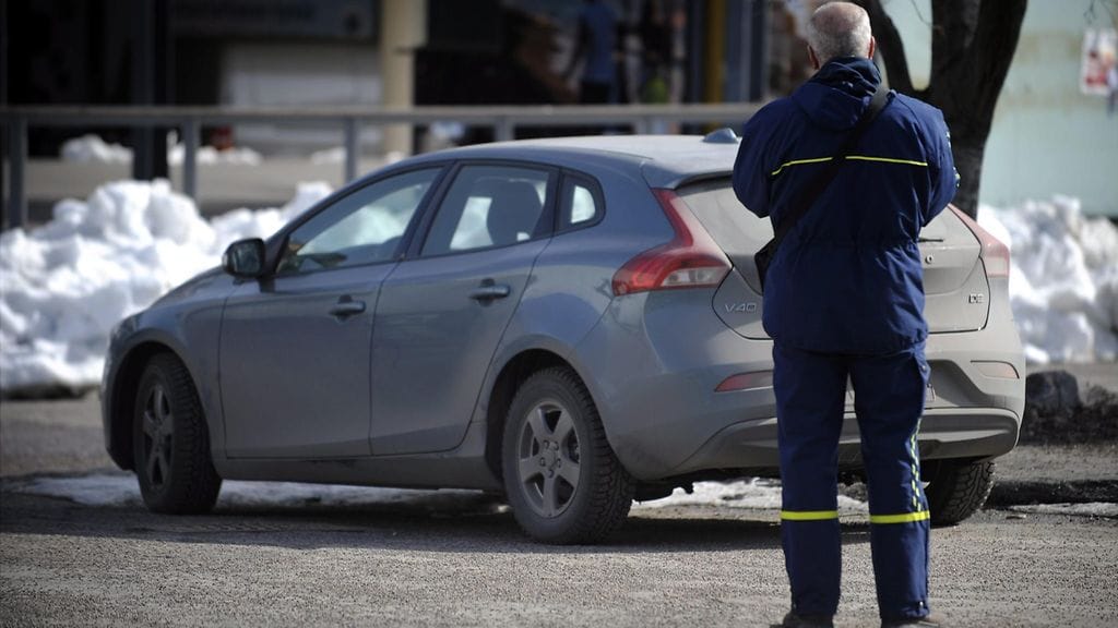 Pysäköinninvalvoja kirjoittamassa virhemaksua Helsingin keskustassa.