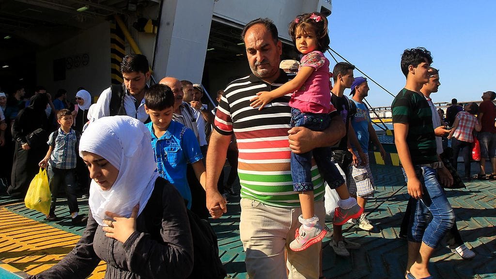 Eleftherios Venizelos -risteilyalus kuljettaa yli 2500 pakolaista. Kuvassa isä kantaa lastaan 20.8.2015, kun laiva oli Kreikassa Piraeuksen saarella.