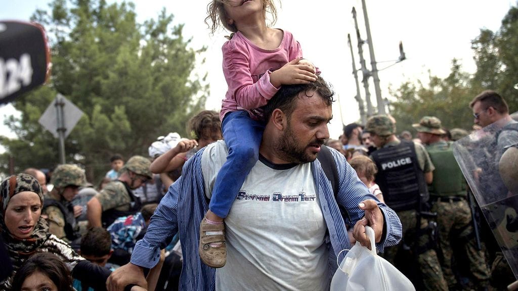 Tytär isänsä olkapäillä Makedoniassa. Tuhansia pakolaisia pidetään Kreikan ja Makedonian välillä.