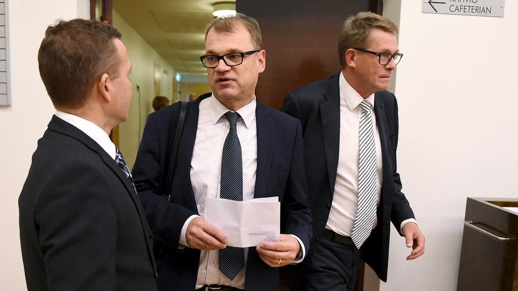 Sisäministeri Petteri Orpo ja pääministeri Juha Sipilä keskustelivat ennen eduskunnan suullista kyselytuntia 10. syyskuuta 2015. Taustalla keskustan eduskuntaryhmän puheenjohtaja Matti Vanhanen.