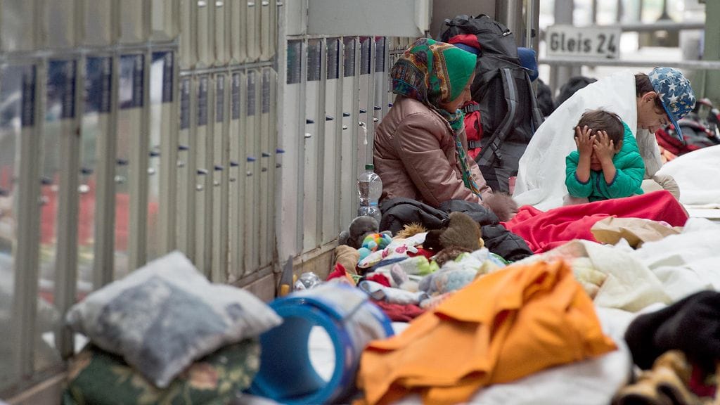 Syyrialaiset, irakilaiset ja pakistanilaiset turvapaikanhakijat nukkuivat Frankfurtin päärautatieasemalla saavuttuaan yöllä junalla Itävallasta.