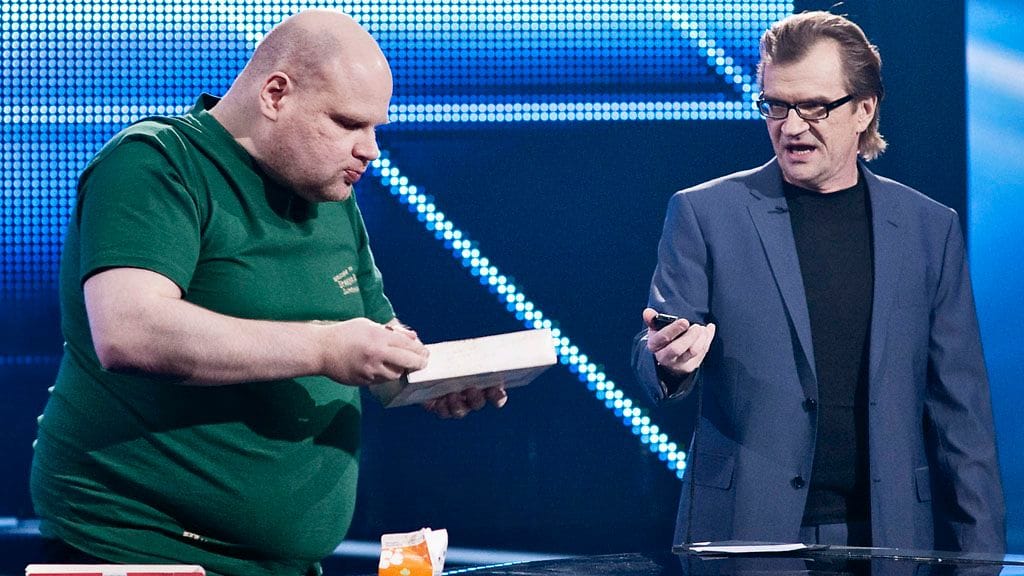 Juhani Lehtonen yrittää mämminsyömisen ennätystä Ennätystehtaan neljännessä jaksossa. Vieressä Antero Mertaranta.