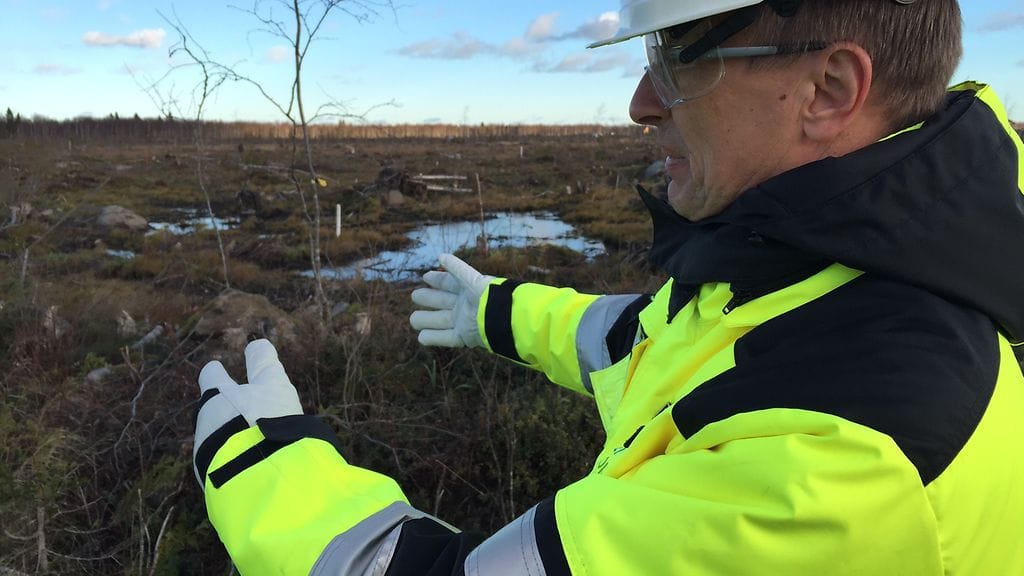 Rakentamisjohtaja Jouni Sipiläinen näyttää, mihin ydinreaktori Hanhikivenniemellä tulee.
