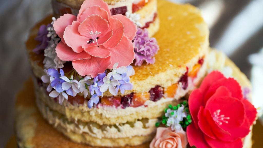 Näyttävät sokerimassaruusut herättävät kakun päällä huomiota.