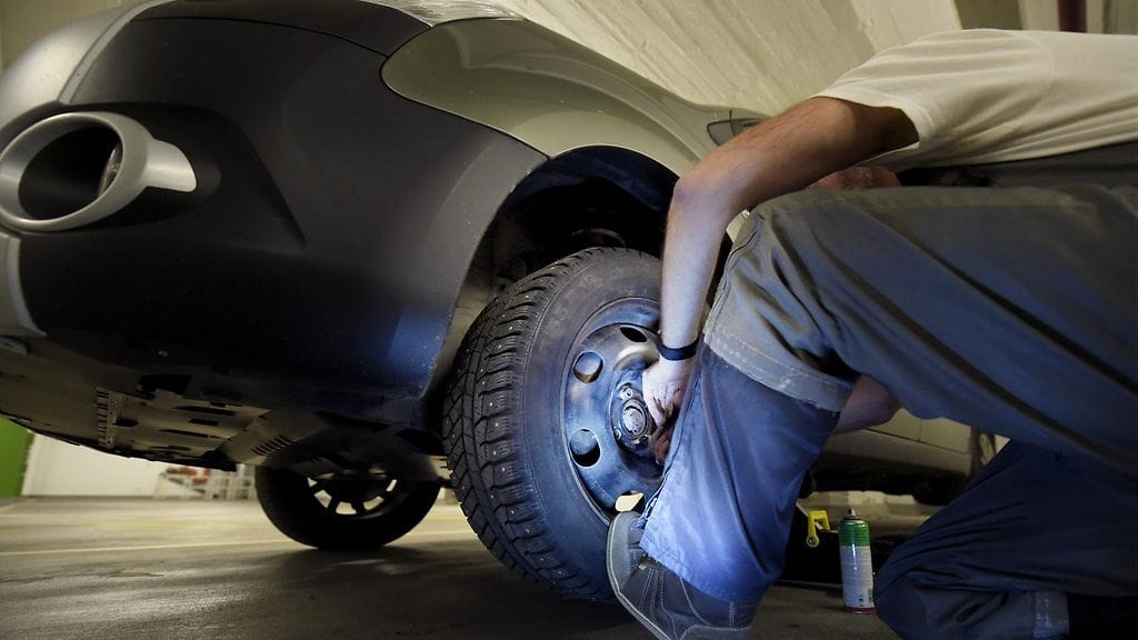 Noin 10-kiloisen autonrenkaan liikuttelu erilaisissa asennoissa alhaalla maanrajassa asettaa ergonomisen haasteen.