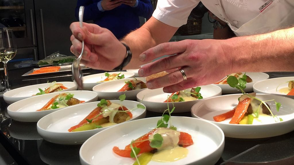 Ravintola Olon Pekka Terävä asettelee lohiannoksia lautaselle.