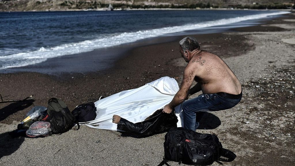 Paikallinen asukas kiskoi hukkuneen miehen ruumista rantaan Lesboksen saarella 30. lokakuuta 2015.