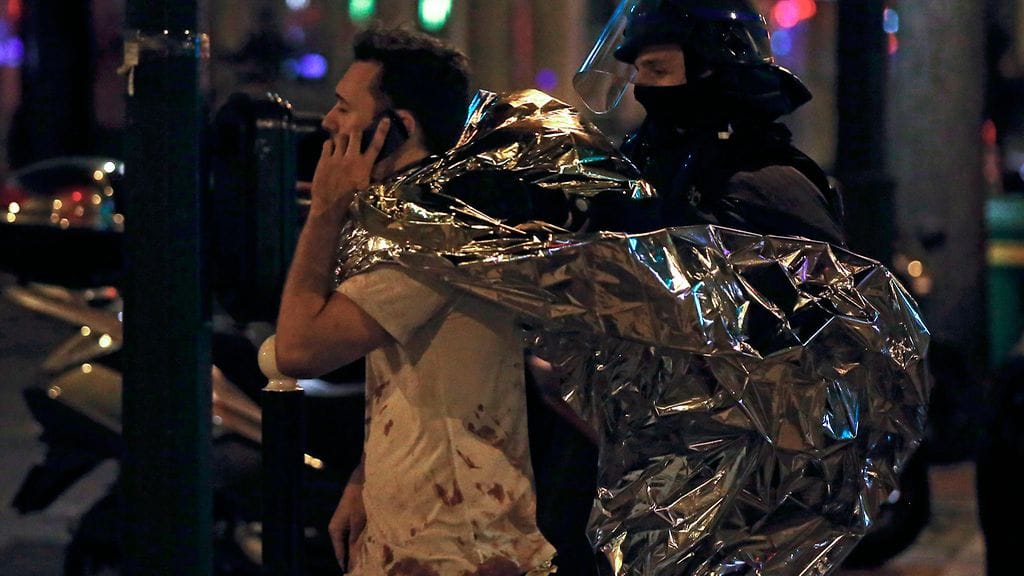 Mies puhui puhelimeen Bataclanin konserttisalin ulkopuolella 14. marraskuuta terrori-iskujen jälkeen.