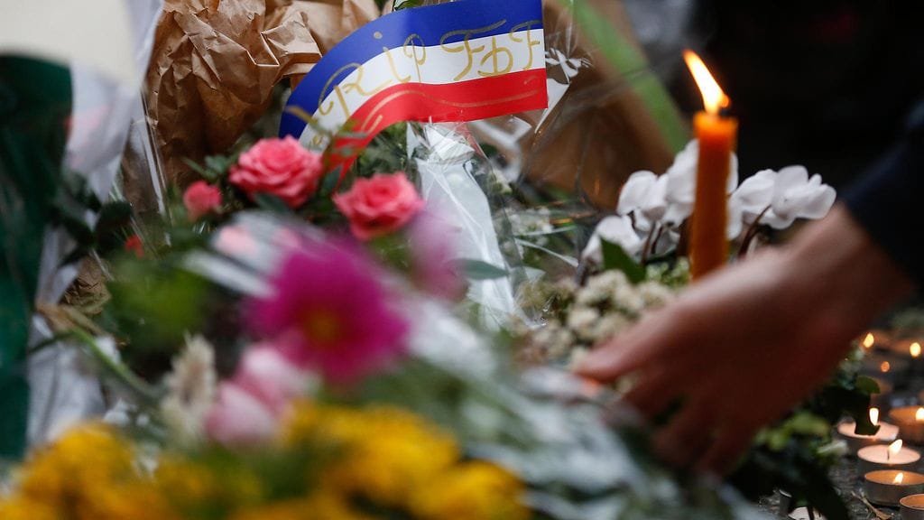 Kukkia ja Ranskan lippu lähellä konserttihallia, johon terroristit iskivät Pariisissa.