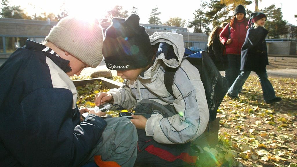 Tuomas Ihonen (vas.) ja Marcel Moore pelaavat matopeliä kännyköillään koulun pihalla Kulosaaressa