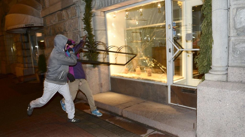 Luokkaretki lähiöst linnaan -mielenosoittajat rikkovat ikkunaa Helsingissä itsenäisyyspäivänä 6. joulukuuta 2014.