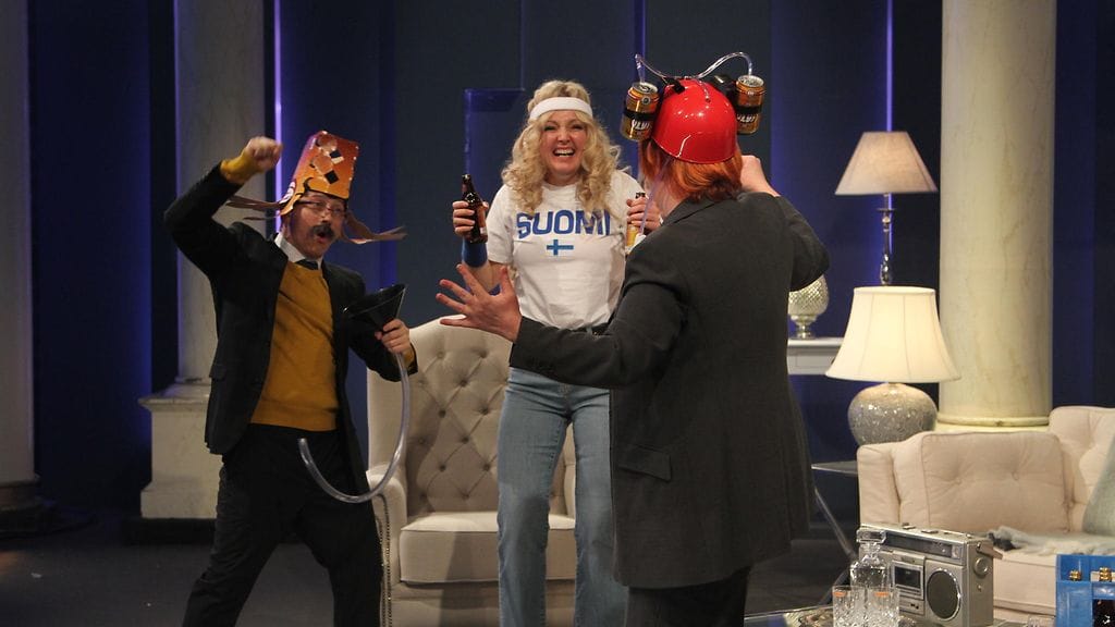 Jenni kokanderin imitoiman Halosen (selin kuvassa) lisäksi sketsissä nähtiin myös esimerkiksi Mari Perankoski Kike Elomaan roolissa.