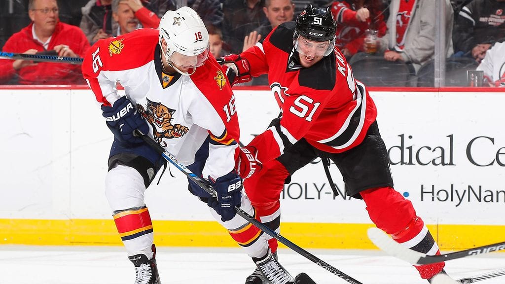 Aleksander Barkov taistelee kiekosta Devilsin Sergei Kalininin kanssa.